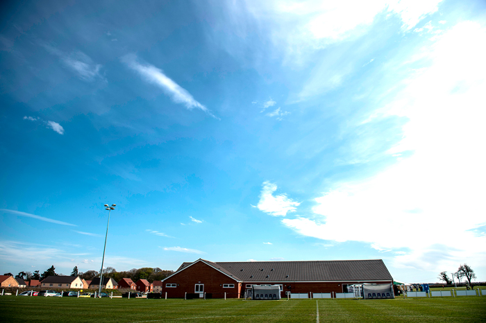 Image of a grassroots football pitch under a clear blue sky