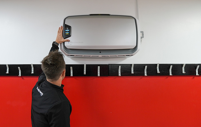 Fellowes staff member operating a wall-mounted Fellowes Air Purifier at Doncaster Rovers