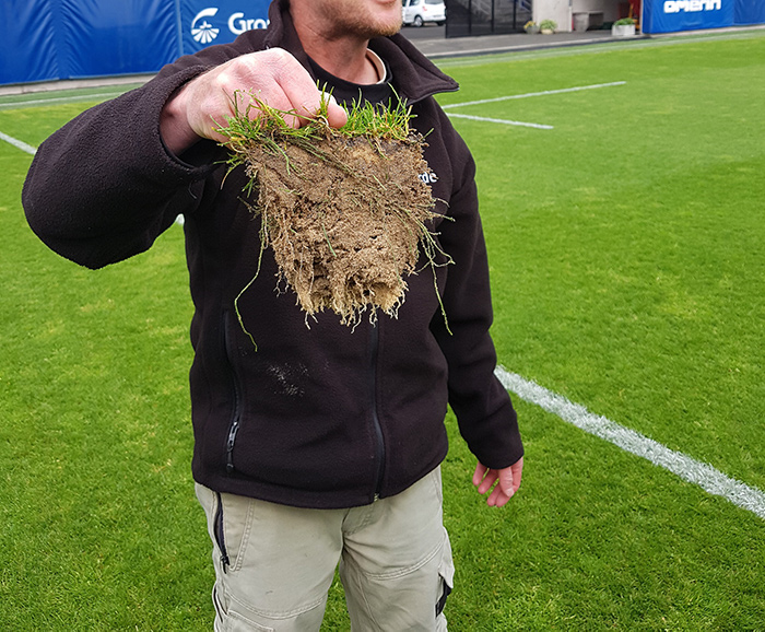 A groundsman holding a lump of turf