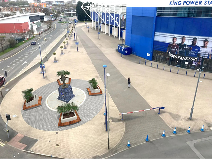 An aerial view of the Khun Vichai statue at King Power Stadium, visible by day.