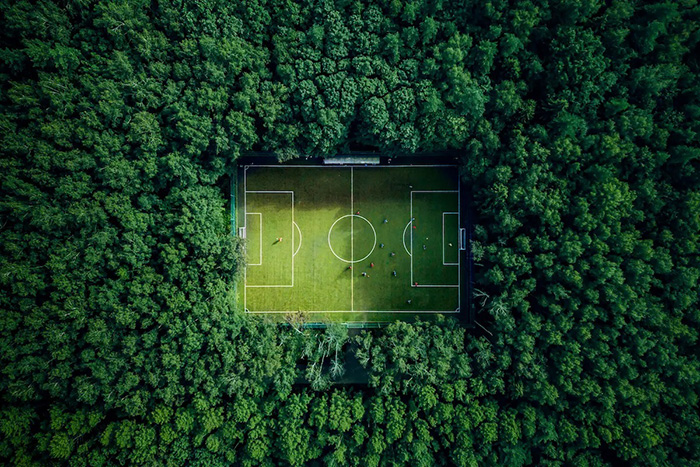 Football and sustainability - a football pitch surrounded by trees viewed from directly overhead