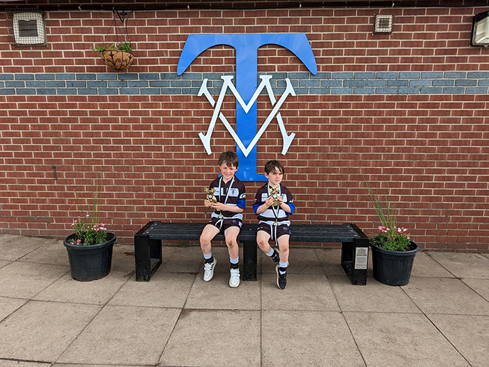 Two children sat on one of the repurposed plastic cups benches from at Twickenham Stadium