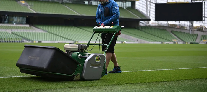 A sports pitch with a pitch cutting machine on it