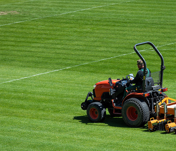 A sports pitch being cut by a ride-on trimmer
