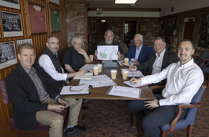 Members of Ayr Rugby Football Club discussing the redevelopment plans around a table