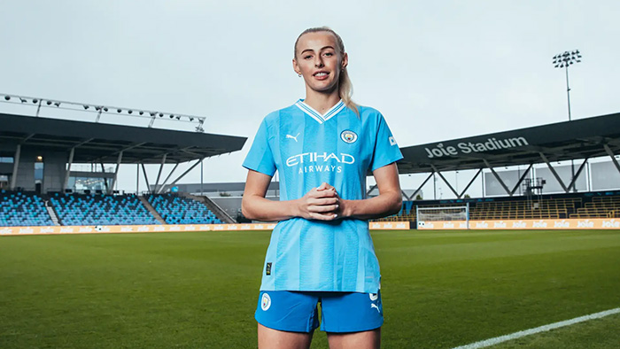 One of the Manchester City Women's team wearing a football shirt branded with Joie stadium