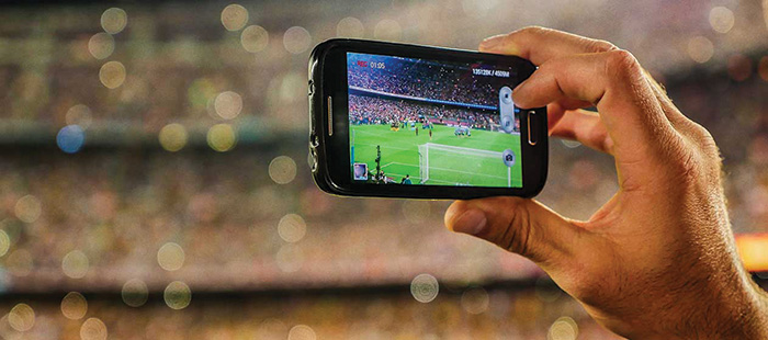 A mobile phone being used to record a football game inside a football stadium