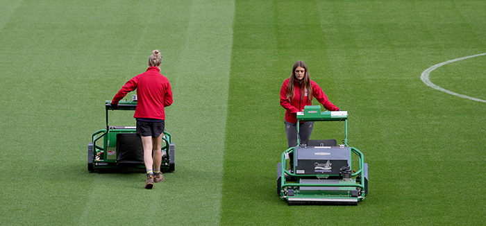 Two female groundstaff mowing the pitch at the Emirates Stadium for Arsenal vs Tottenham in the Barclays Women’s Super League