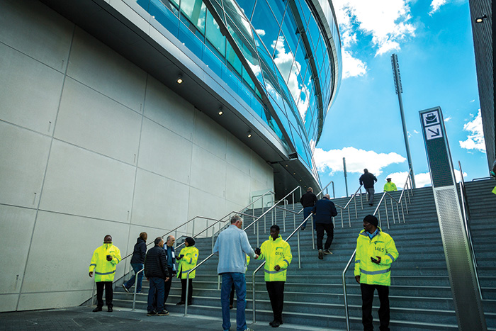 security guards checking tickets on the way to a football stadium