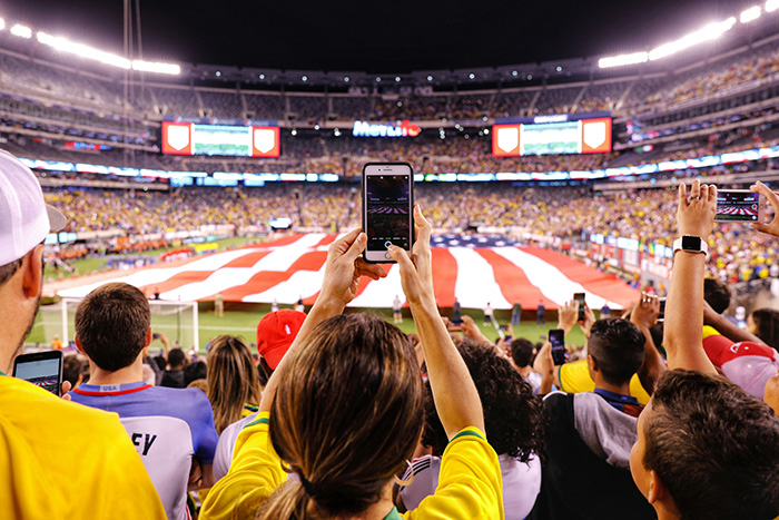 A person using a phone at in a stadium during a football match