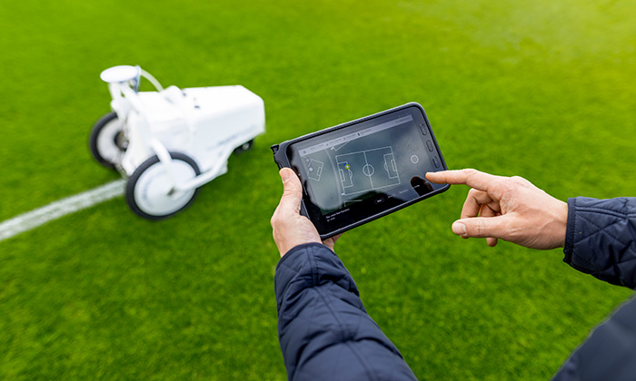 TinyLineMarker Robot from Origin Amenity Solutions being controlled by a user via the app