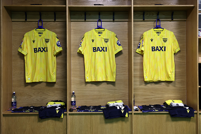 Three Oxford United Football Club shirts hanging in a locker, with Baxi sponsorship