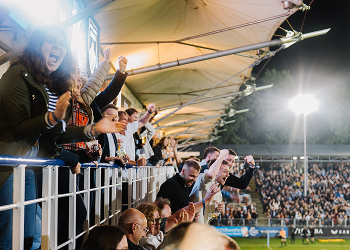 Fans cheering at a game at Bath Rugby