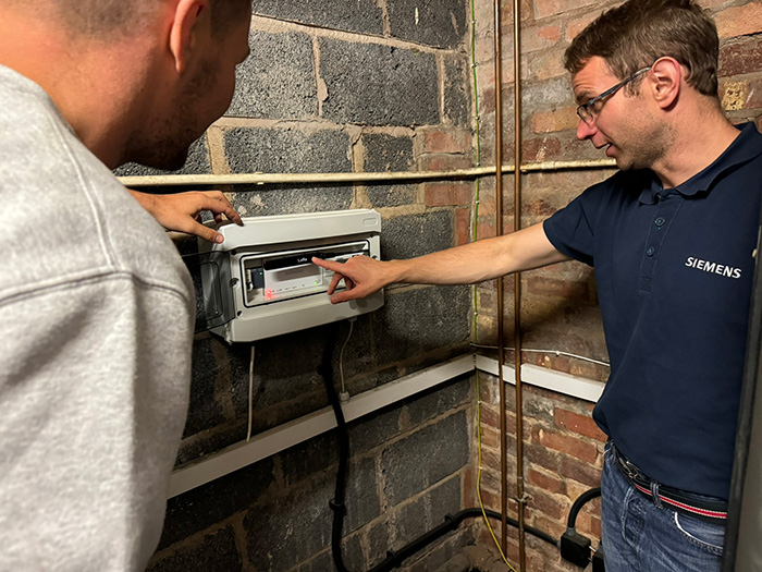 Chris Goodman of Siemens (right) and Nathan Tilsley of PRT Heating check the Connect Box controller in the plant room of Barkers’ Butts RFC.