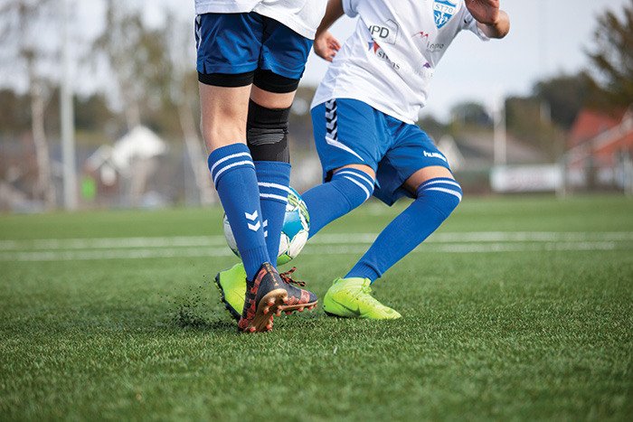 Grassroots footballers playing on a synthetic turf